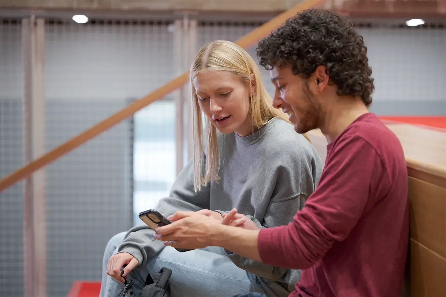 Two students look at a smartphone